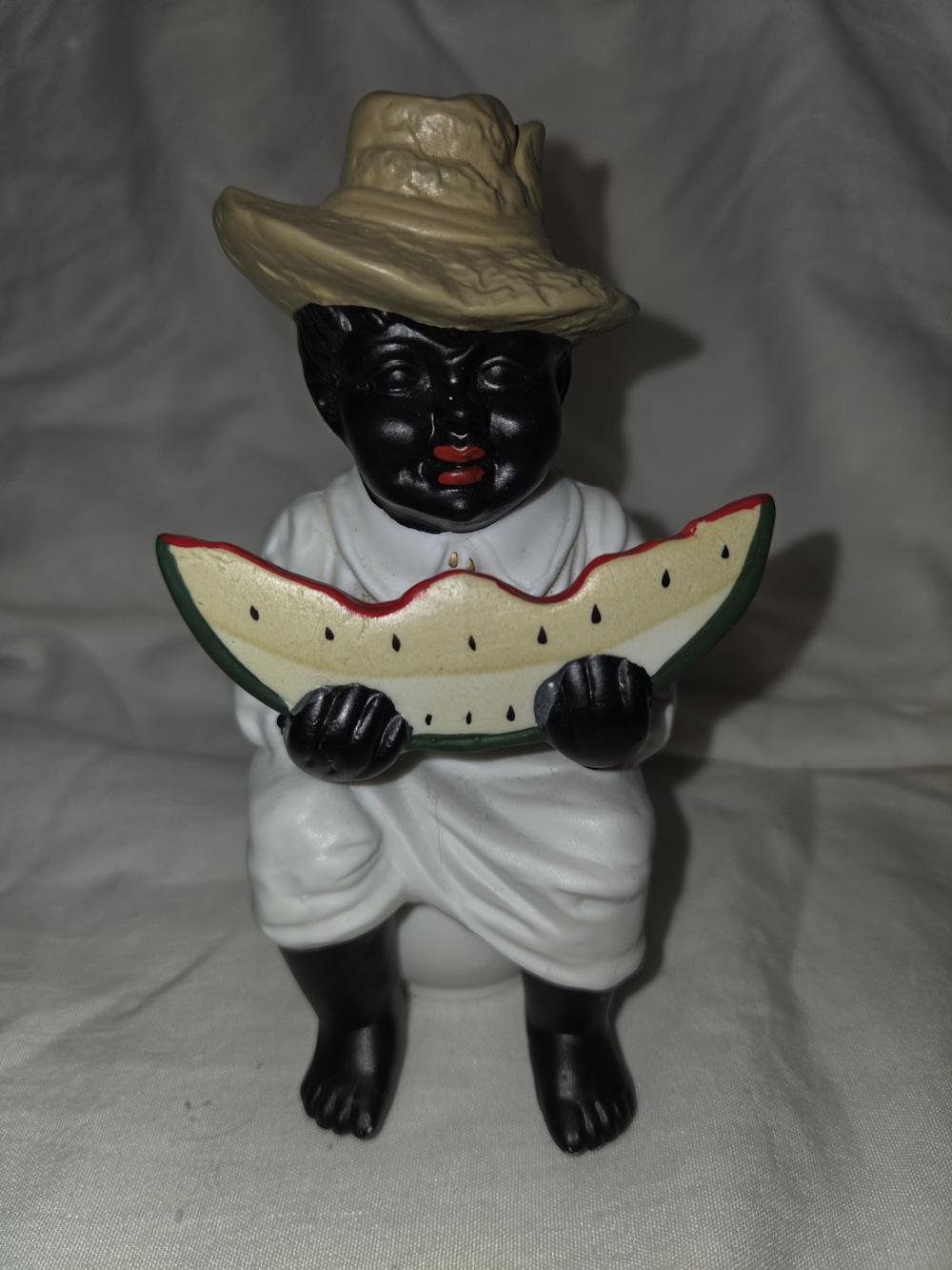 Vintage-Style Black Figurine with Tan Hat and White Outfit Holding Watermelon